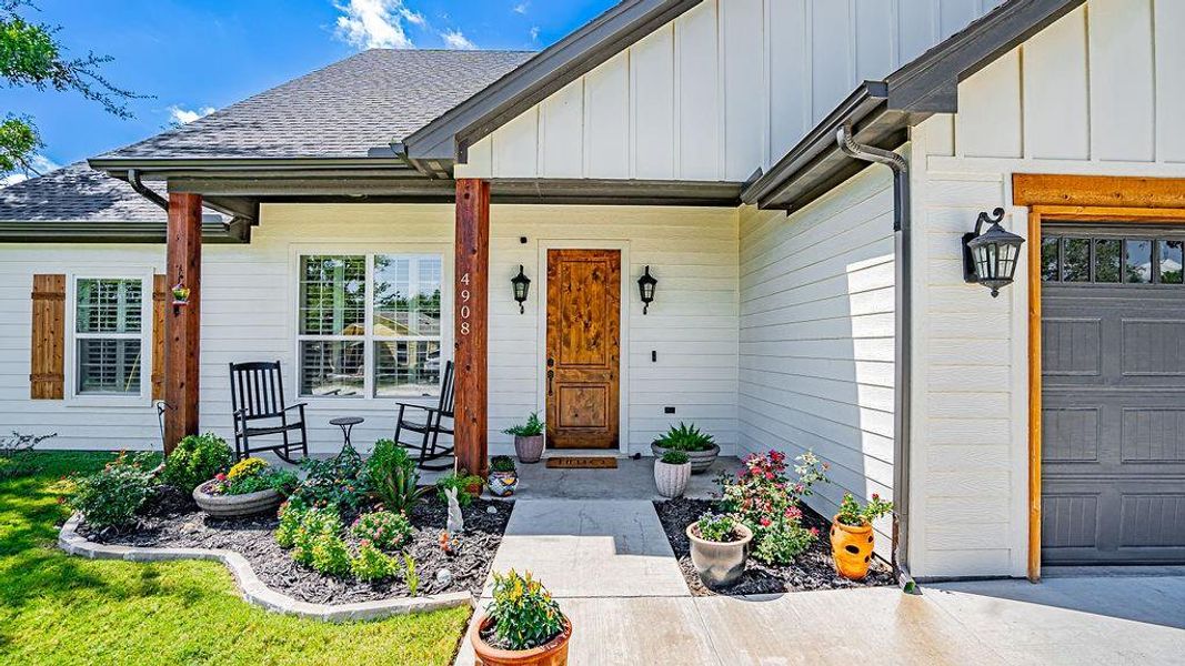 Doorway to property featuring covered porch and a garage