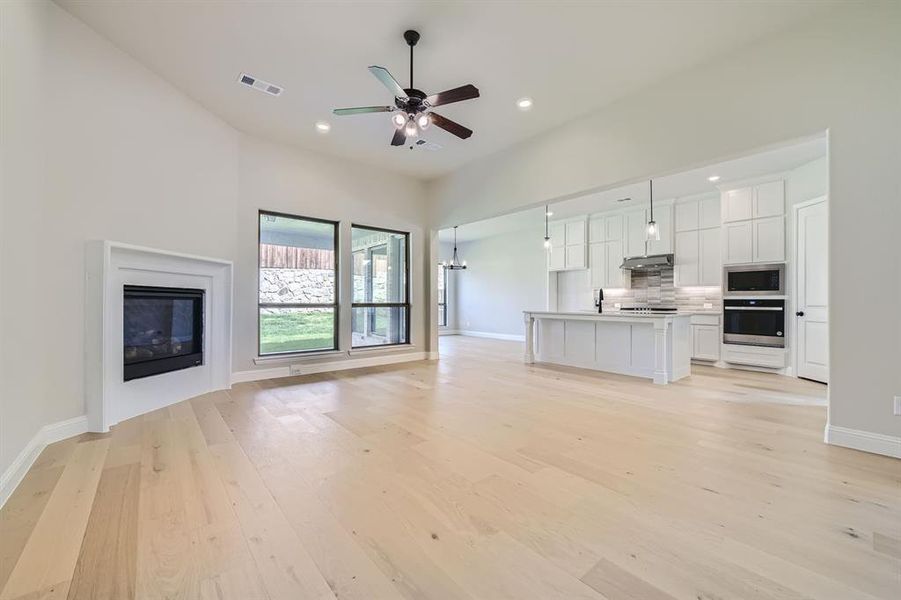 Unfurnished living room featuring sink, ceiling fan, and light hardwood / wood-style floors