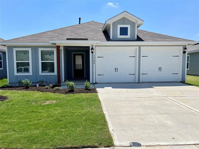 View of front facade with a front yard and a garage