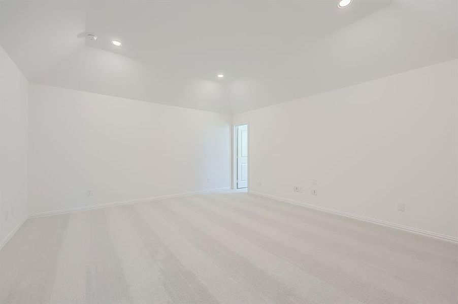 Media room featuring light carpet and vaulted ceiling