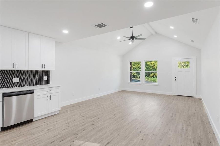 Kitchen with ceiling fan, white cabinets, tasteful backsplash, dishwasher, and light wood-type flooring