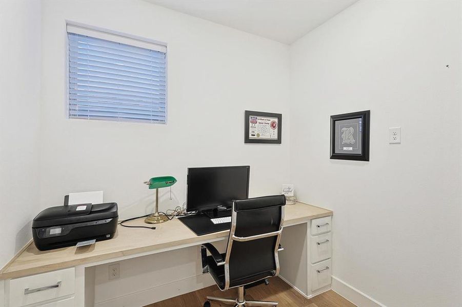 Home office with light hardwood / wood-style flooring