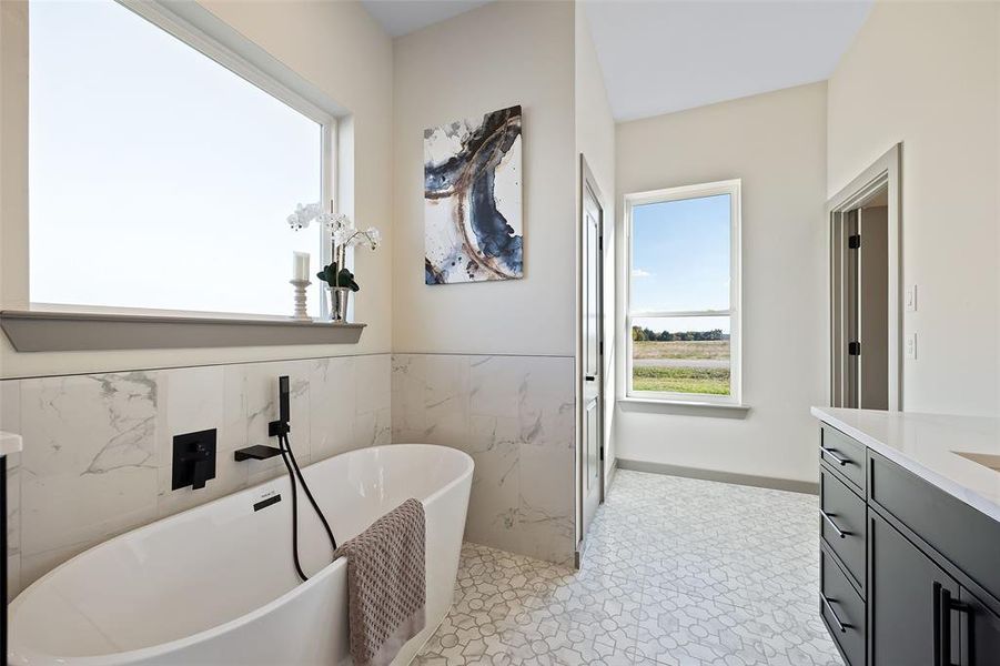 Bathroom featuring a bathing tub, vanity, tile walls, and tile patterned flooring