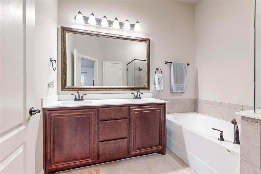 Bathroom with tile patterned flooring, vanity, and independent shower and bath