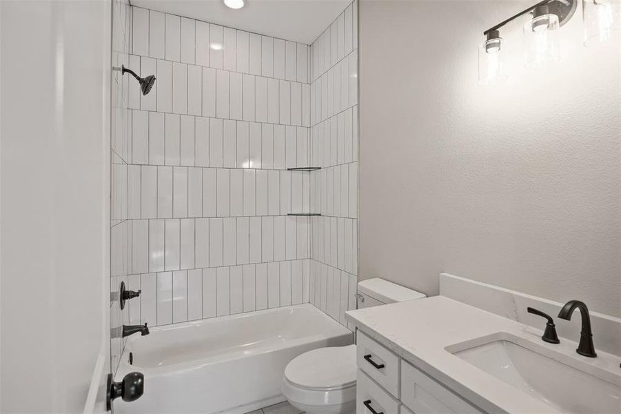 Full bathroom with vanity, toilet, and tiled shower / bath combo