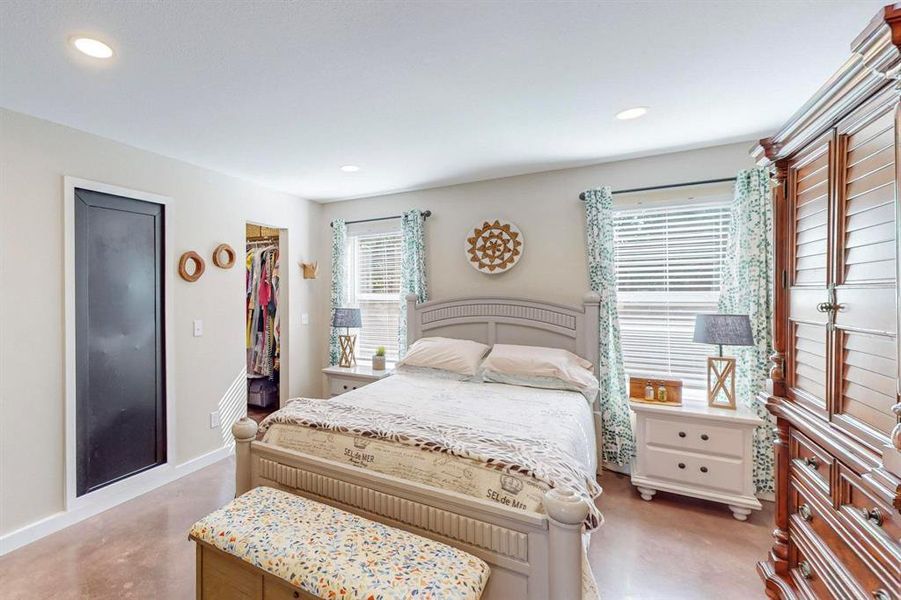 Bedroom featuring a spacious closet, a closet, and concrete floors