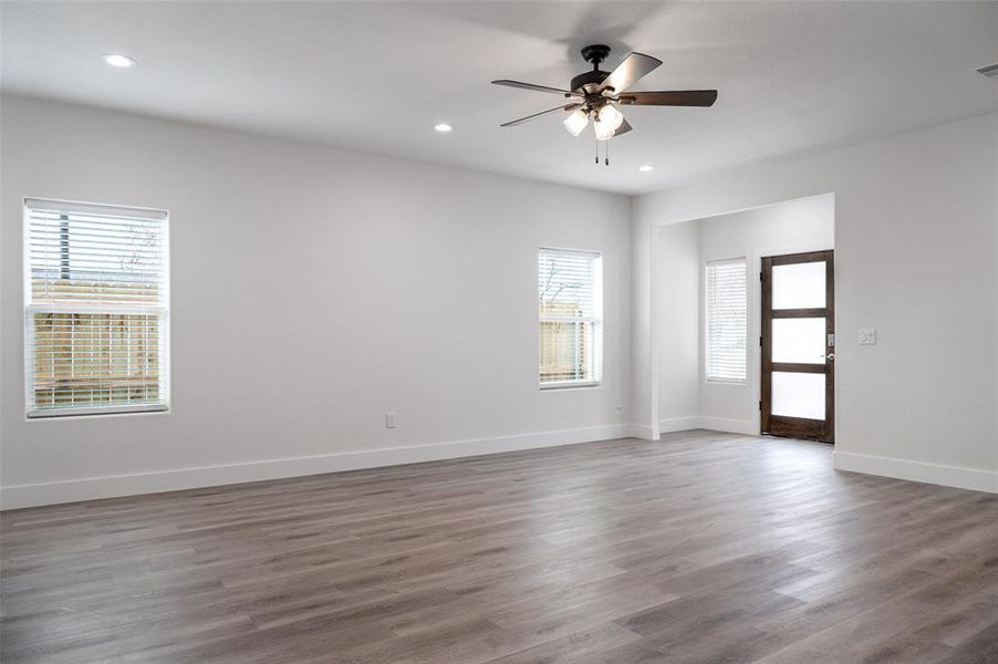 Unfurnished room featuring a healthy amount of sunlight, hardwood / wood-style floors, and ceiling fan