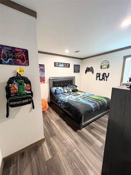 Bedroom with crown molding and wood-type flooring