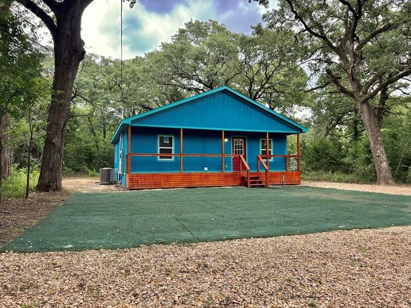 View of front of home with central air condition unit and a porch