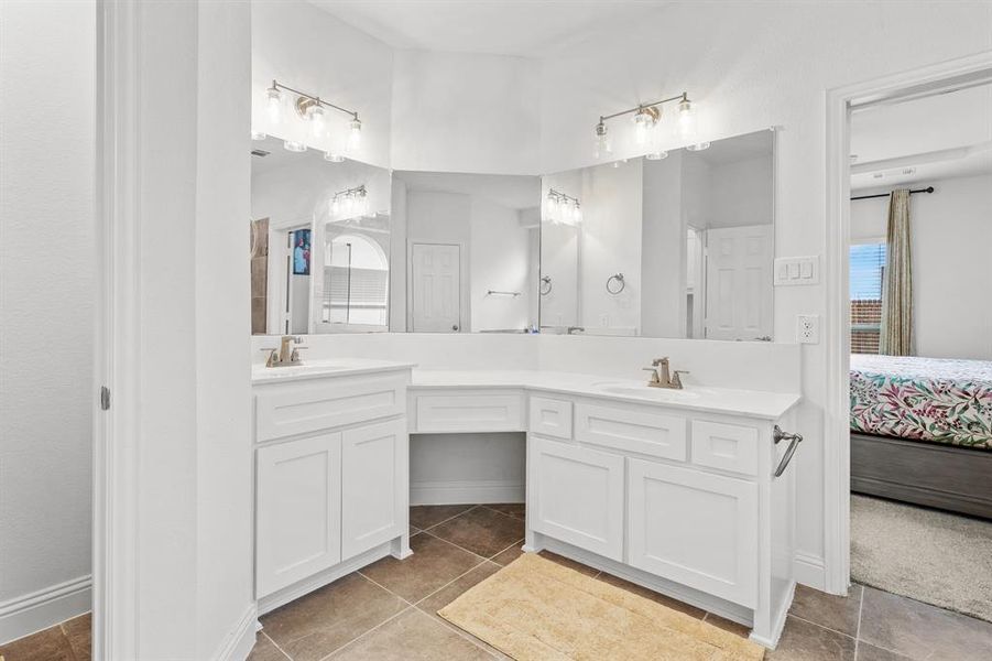 Bathroom featuring vanity, tile patterned floors, and a wealth of natural light