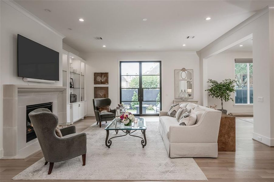 Another perspective of the living room/den showcasing the glass and metal French doors that peer onto the yard.