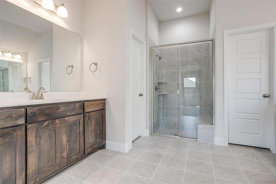 Bathroom featuring vanity, an enclosed shower, and tile patterned floors