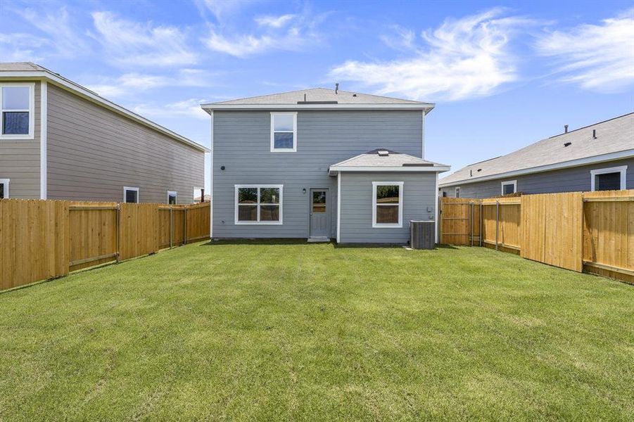 Rear view of house with a yard and central air condition unit