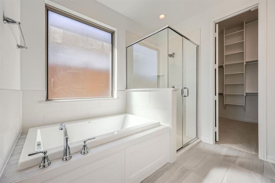 Bathroom with shower with separate bathtub and tile patterned flooring