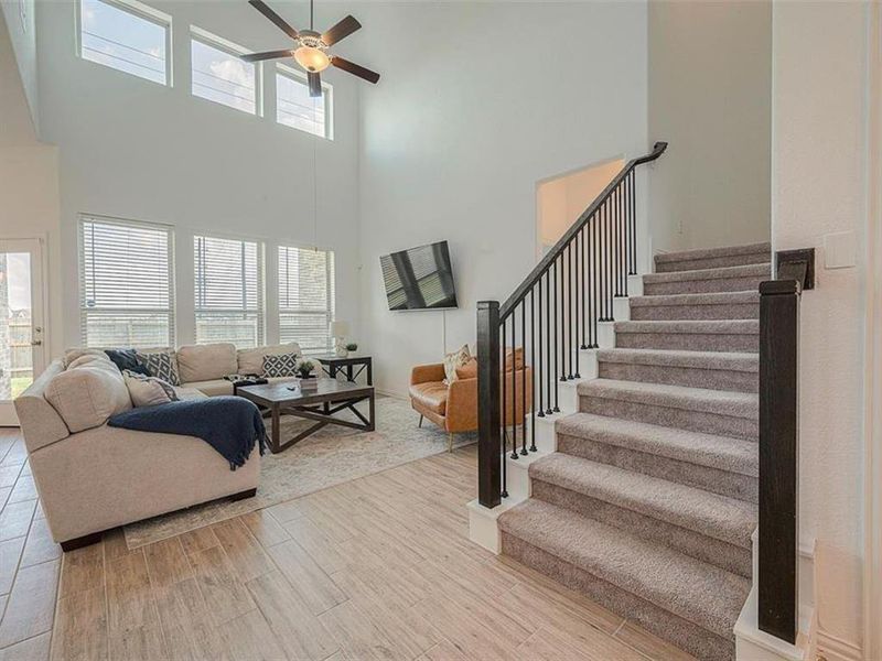 This spacious living room features an open floor plan and a staircase leading to the upper level. The openness creates a light and airy feel, perfect for entertaining.