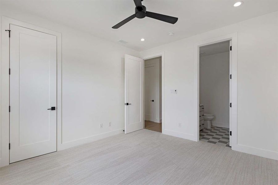 Unfurnished bedroom featuring ceiling fan, light colored carpet, a closet, and connected bathroom