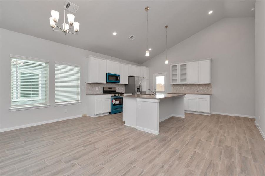 This angle of the kitchen highlights the functional design and modern amenities, including stainless steel appliances and a large island perfect for meal prep or casual dining. The clean lines and open layout create a space that is both practical and aesthetically pleasing, ideal for daily living and entertaining guests. **This image is from another Saratoga Home - Wren floorplan.**