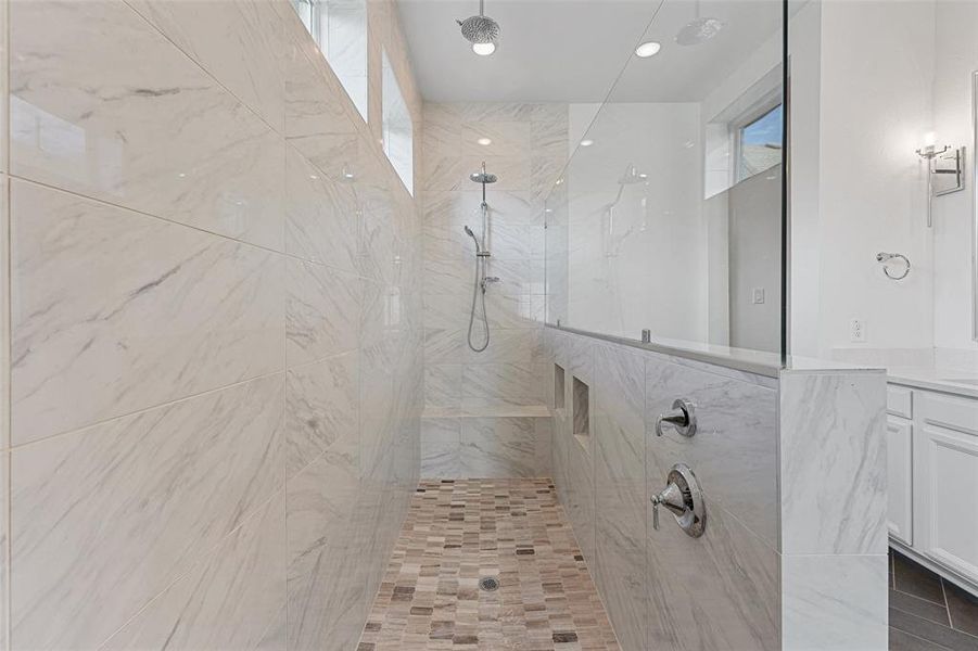 stunning primary bathroom, featuring an oversized walk-in shower that’s the epitome of relaxation.