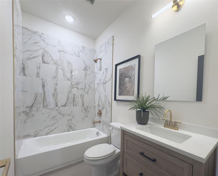 Full bathroom with tiled shower / bath, toilet, and vanity