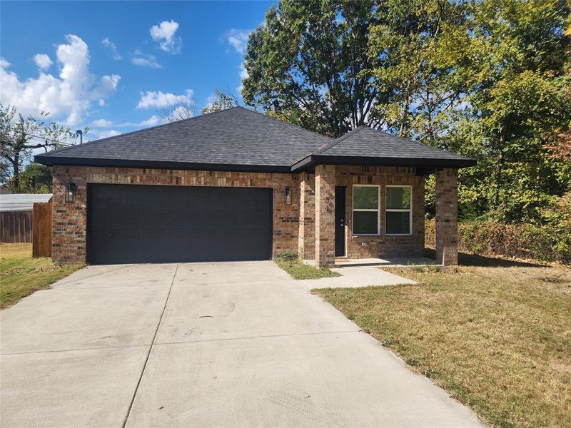 View of front of house with a front lawn and a garage