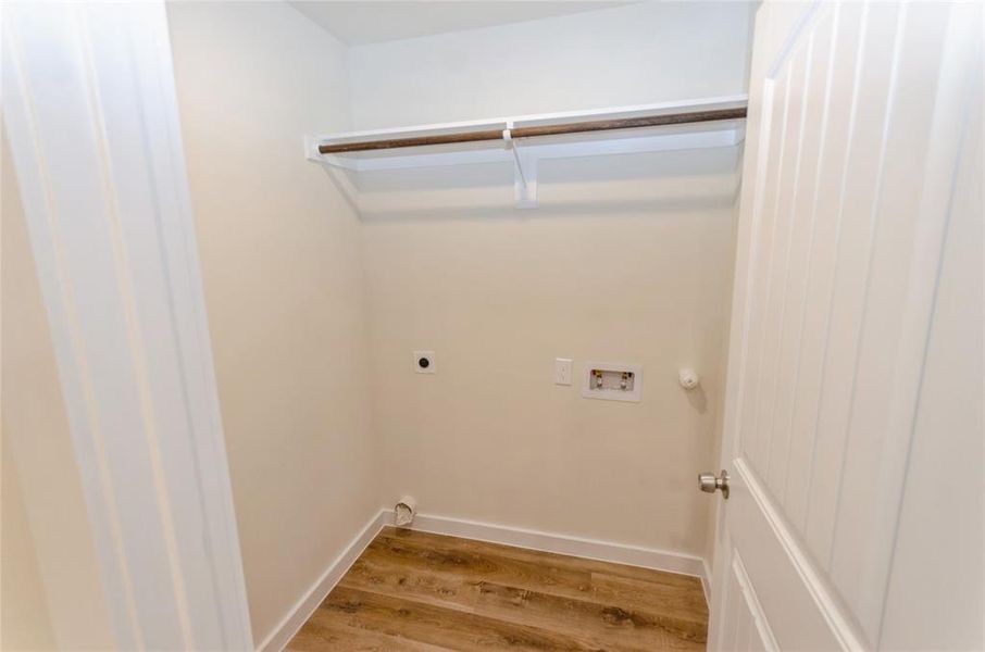 Clothes washing area with washer hookup, hookup for a gas dryer, electric dryer hookup, and hardwood / wood-style floors