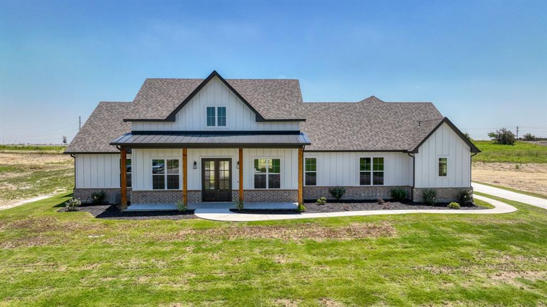 Modern farmhouse with a front yard and a porch