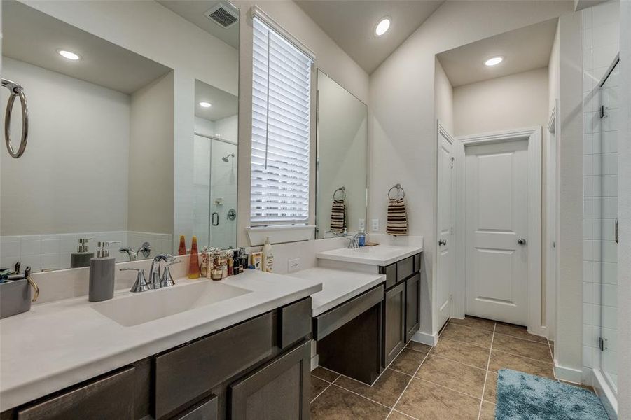 Bathroom with vanity, lofted ceiling, a shower with door, and tile patterned floors