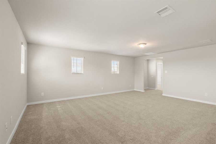 An additional view of the Spacious Flex Space located on the second level which offers plush carpet, attic access, high ceilings and plenty of space for all your entertaining needs!