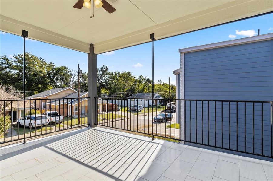 View of patio with ceiling fan and a balcony