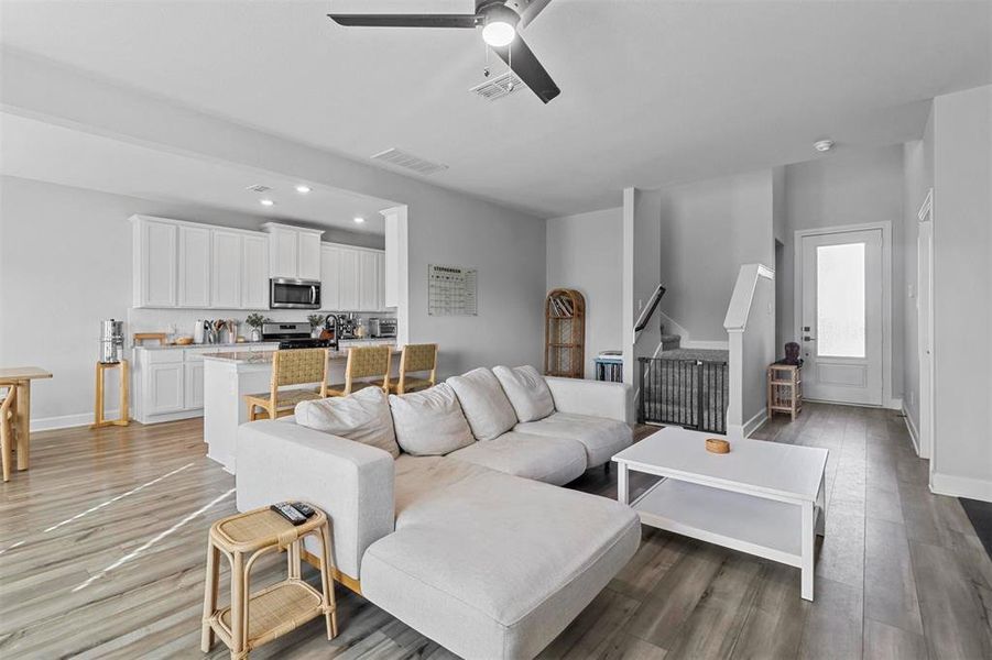 Living room with ceiling fan and light wood-type flooring