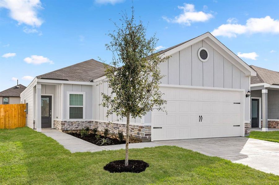 This home has a beautiful, modern design with garage door accents and a nice tree in the front yard to provide shade in the coming years.