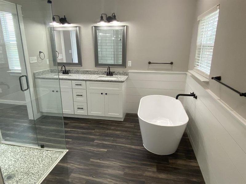 Bathroom with plus walk in shower, hardwood / wood-style floors, vanity, and tile walls