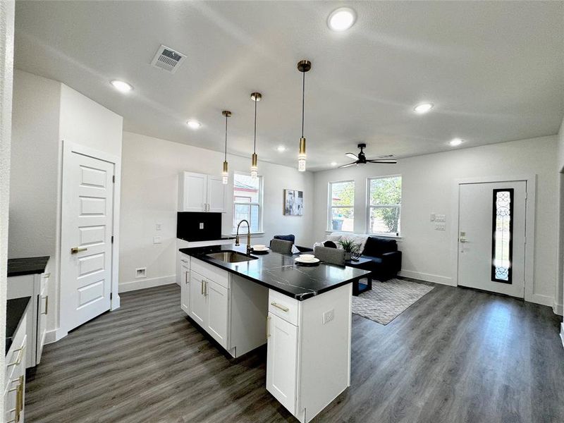 Kitchen featuring a kitchen island with sink, white cabinetry, sink, and ceiling fan