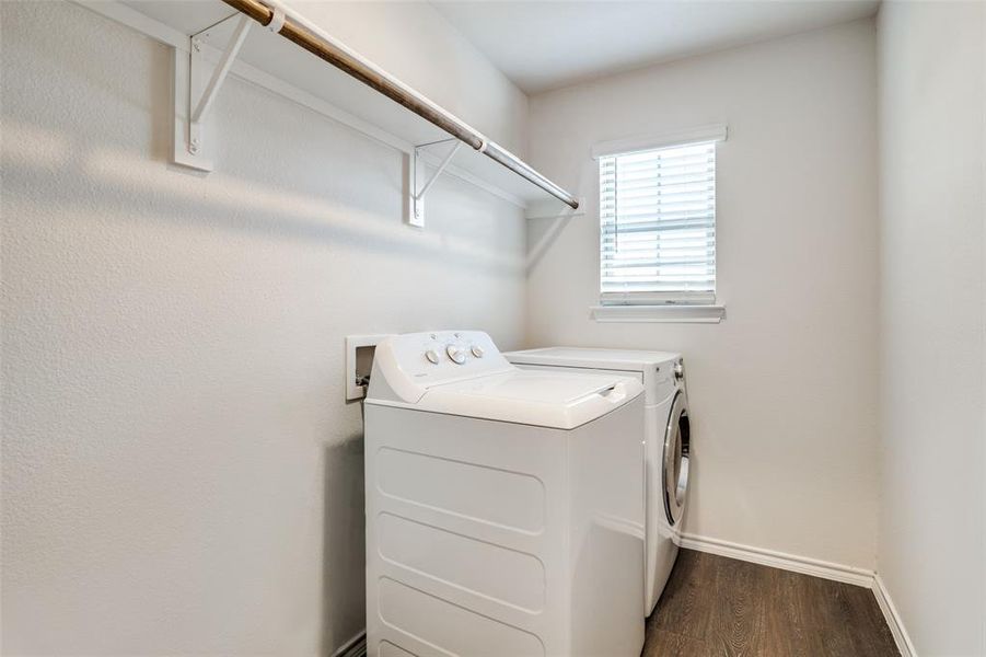 Clothes washing area featuring dark wood-type flooring and separate washer and dryer