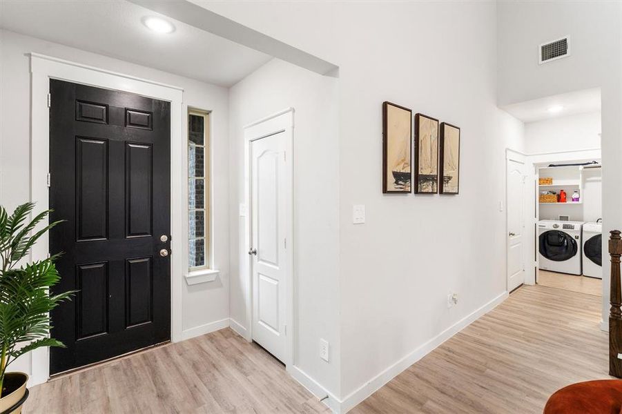 Foyer featuring washing machine and clothes dryer and light wood-type flooring