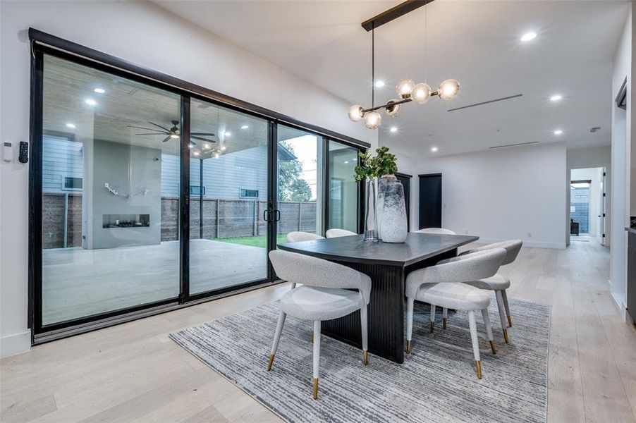 Dining space featuring light hardwood / wood-style flooring and ceiling fan with notable chandelier