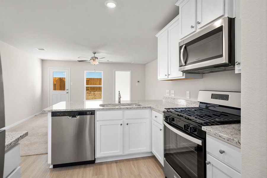 Stainless Steel appliances with white cabinets.