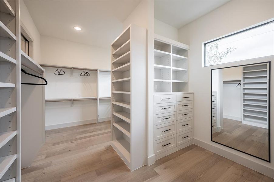 The primary suite's double walk-in closet neatly attends to the wardrobeneeds with extensive hanging rods, shoe shelves, and drawers.