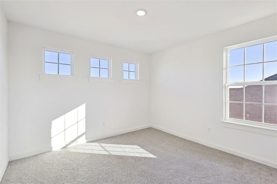 Unfurnished room with light carpet and a healthy amount of sunlight