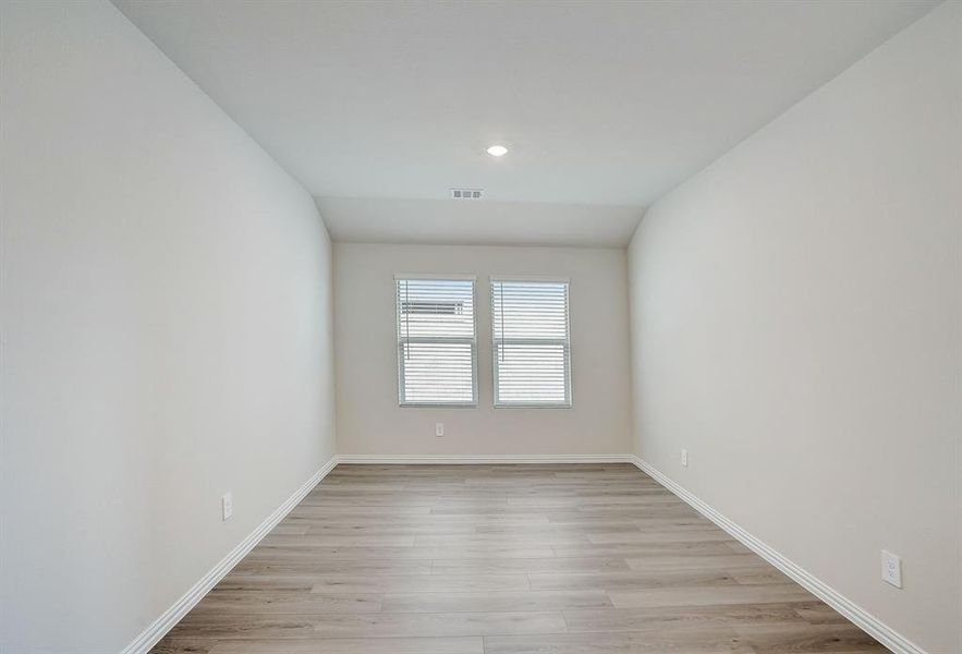 Room vaulted ceiling and light wood-type flooring