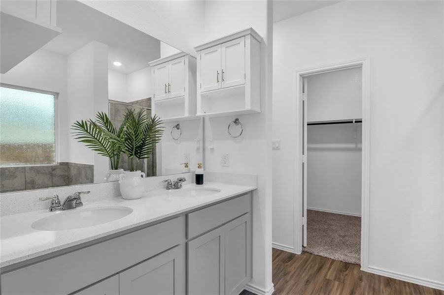 Primary bathroom with dual vanities and added cabinetry for more storage