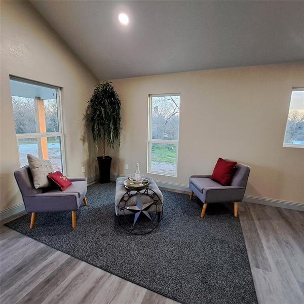 Living room with hardwood / wood-style flooring and vaulted ceiling