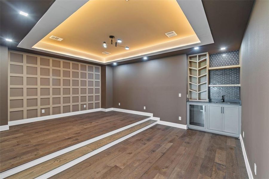 Spare room with dark hardwood / wood-style floors and a raised ceiling