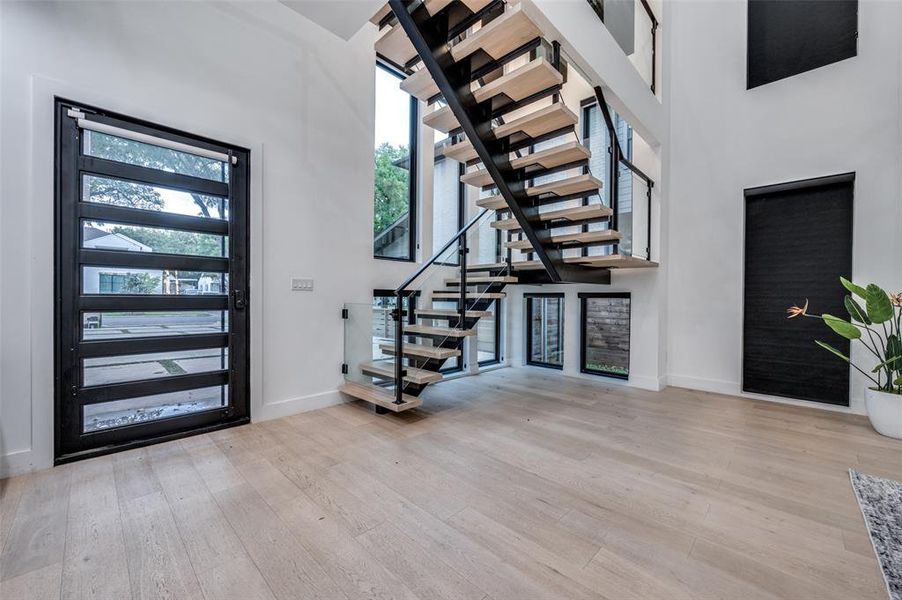 Foyer with a towering ceiling and light wood-type flooring