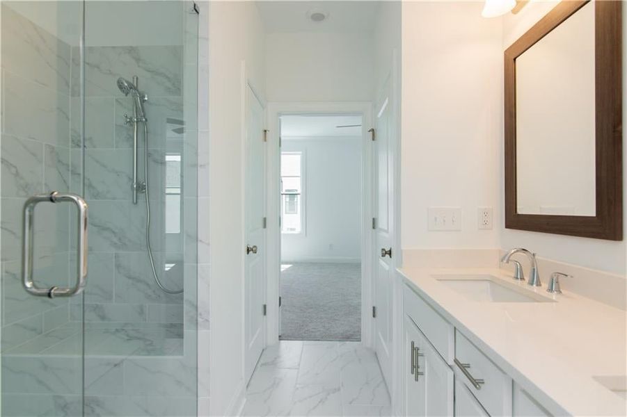 Master Bathroom featuring a shower with door, vanity, and tile patterned floors not the actual unit