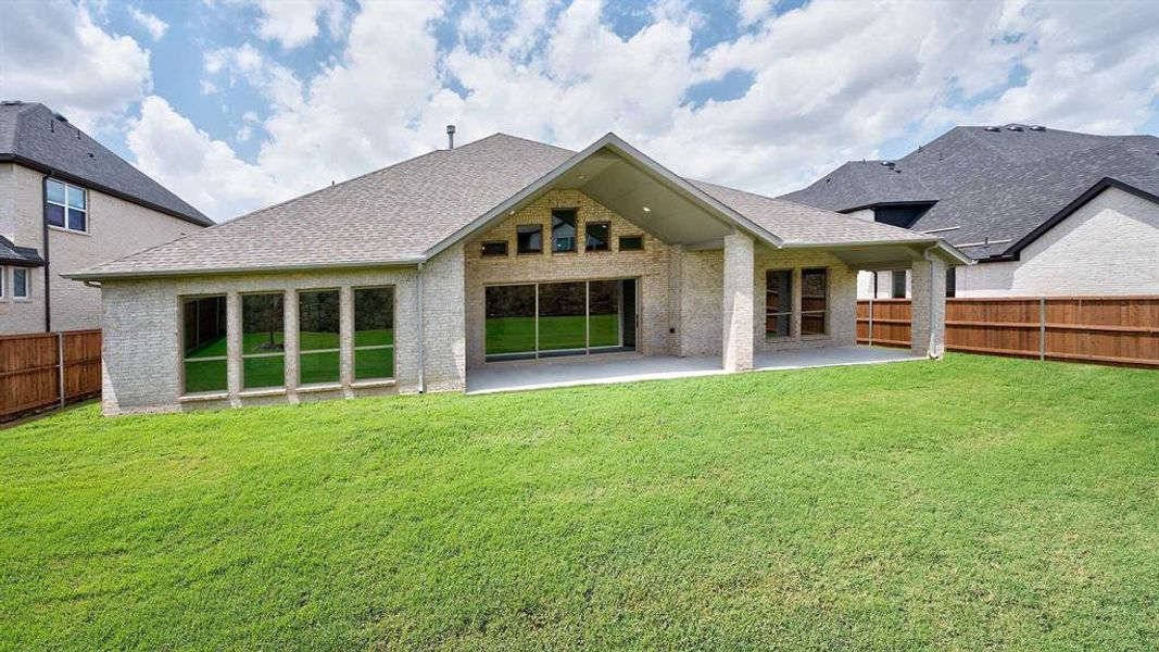 Back of property with a lawn and a patio area