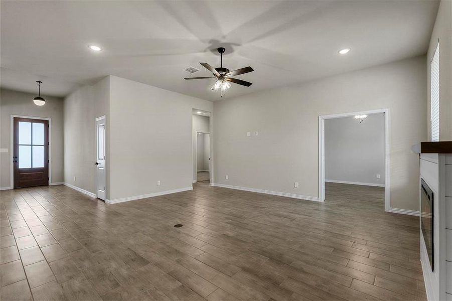 Unfurnished living room featuring hardwood / wood-style floors and ceiling fan