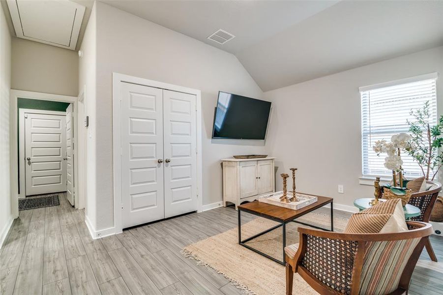 Living room with light wood-type flooring and vaulted ceiling