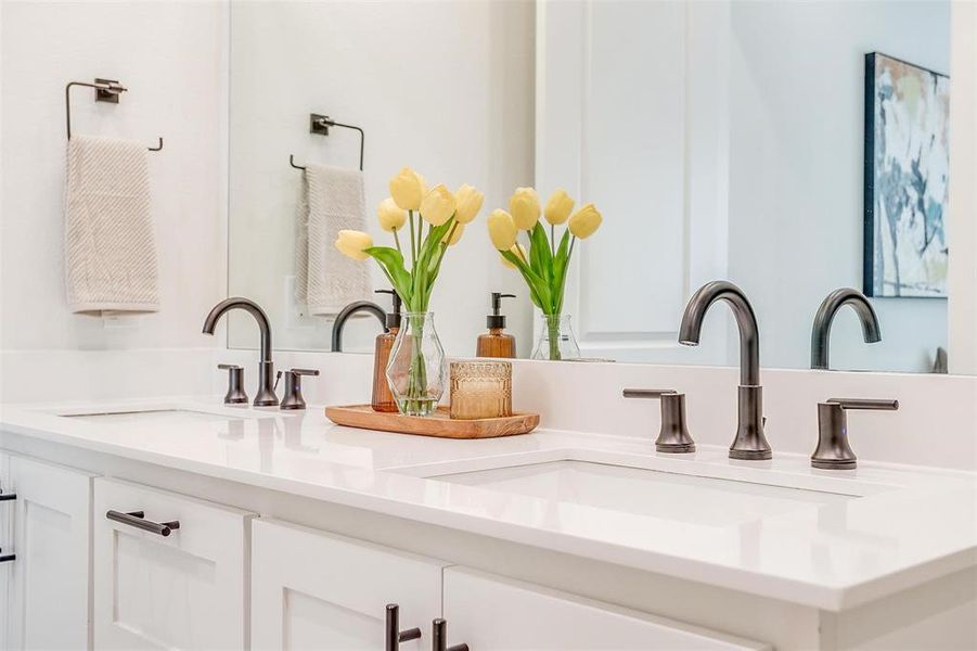 Indulge in the luxurious features of the primary bathroom, including quartz countertops, dual vanities with ample storage space, and Delta plumbing fixtures. This well-appointed space combines functionality with elegance, offering a spa-like experience right at home.
