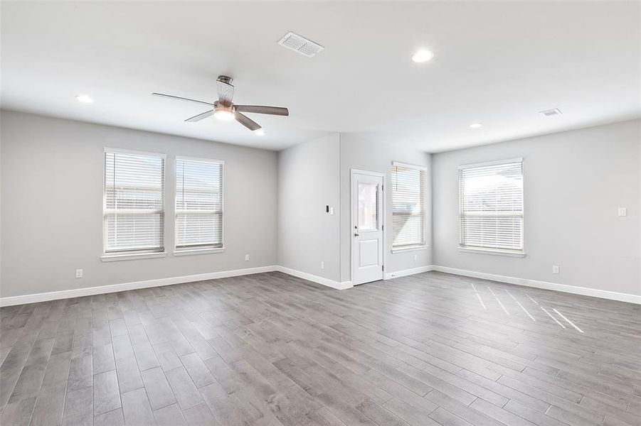 Unfurnished living room featuring hardwood / wood-style flooring and ceiling fan